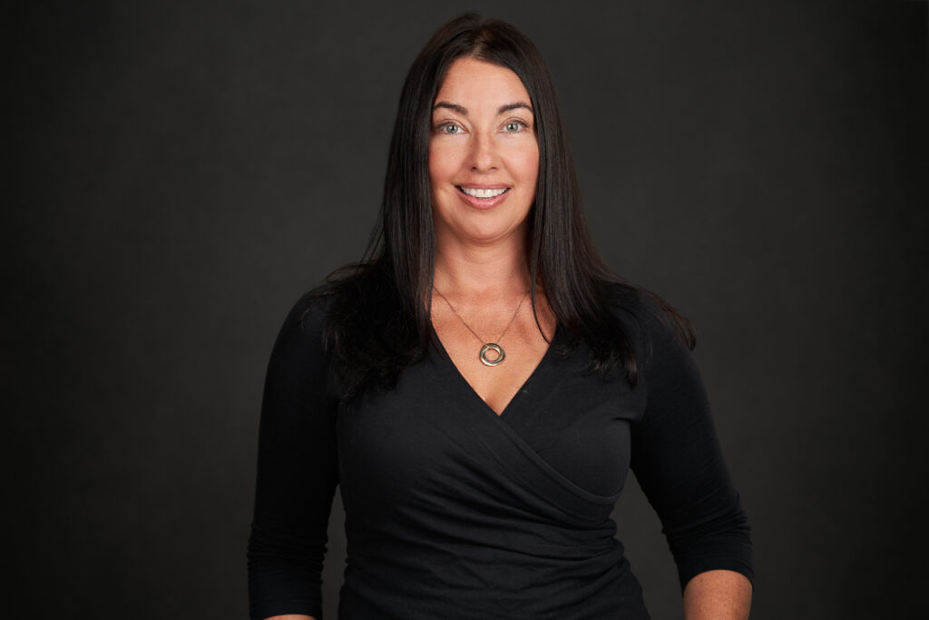 A woman in black shirt smiling for the camera.